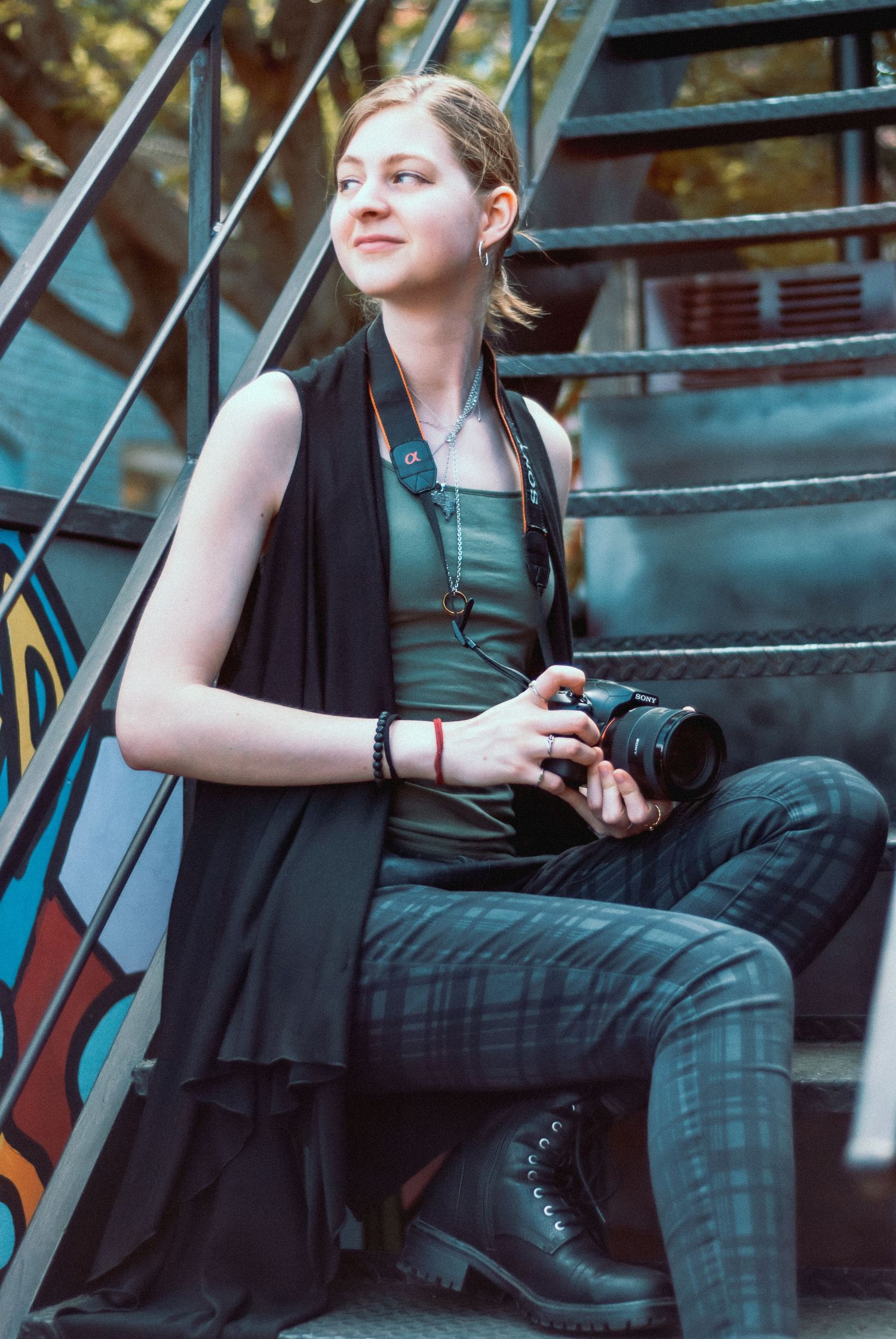Sarah from S. C. Evans Photography, LLC sitting on staircase, holding her camera at wedding  in downtown Bowling Green, Kentucky