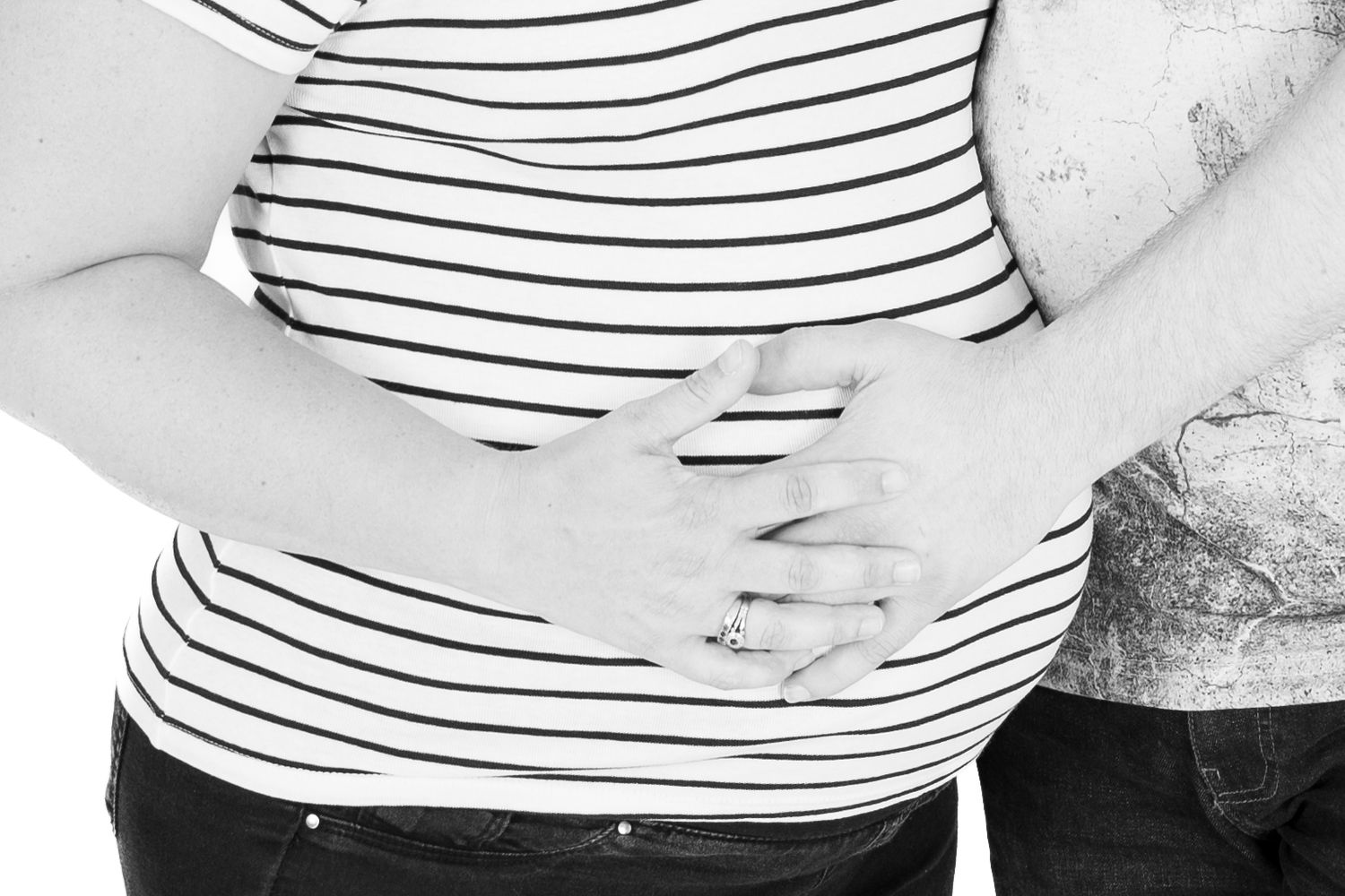 Person in striped shirt stands against a light background while gesturing with their hands.