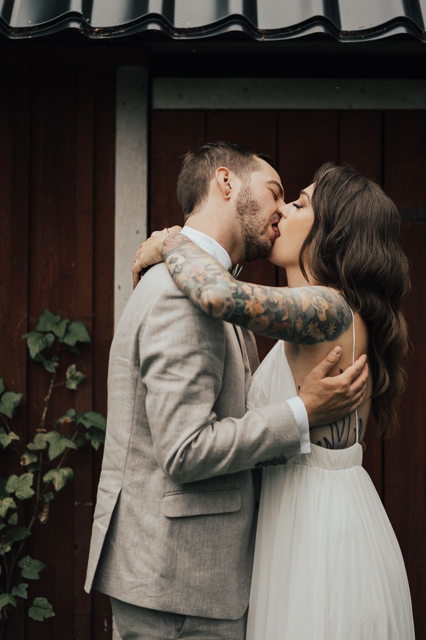 Brudpar kysser varandra så att tungorna syns på en bröllopsfotografering i Eskilstuna.