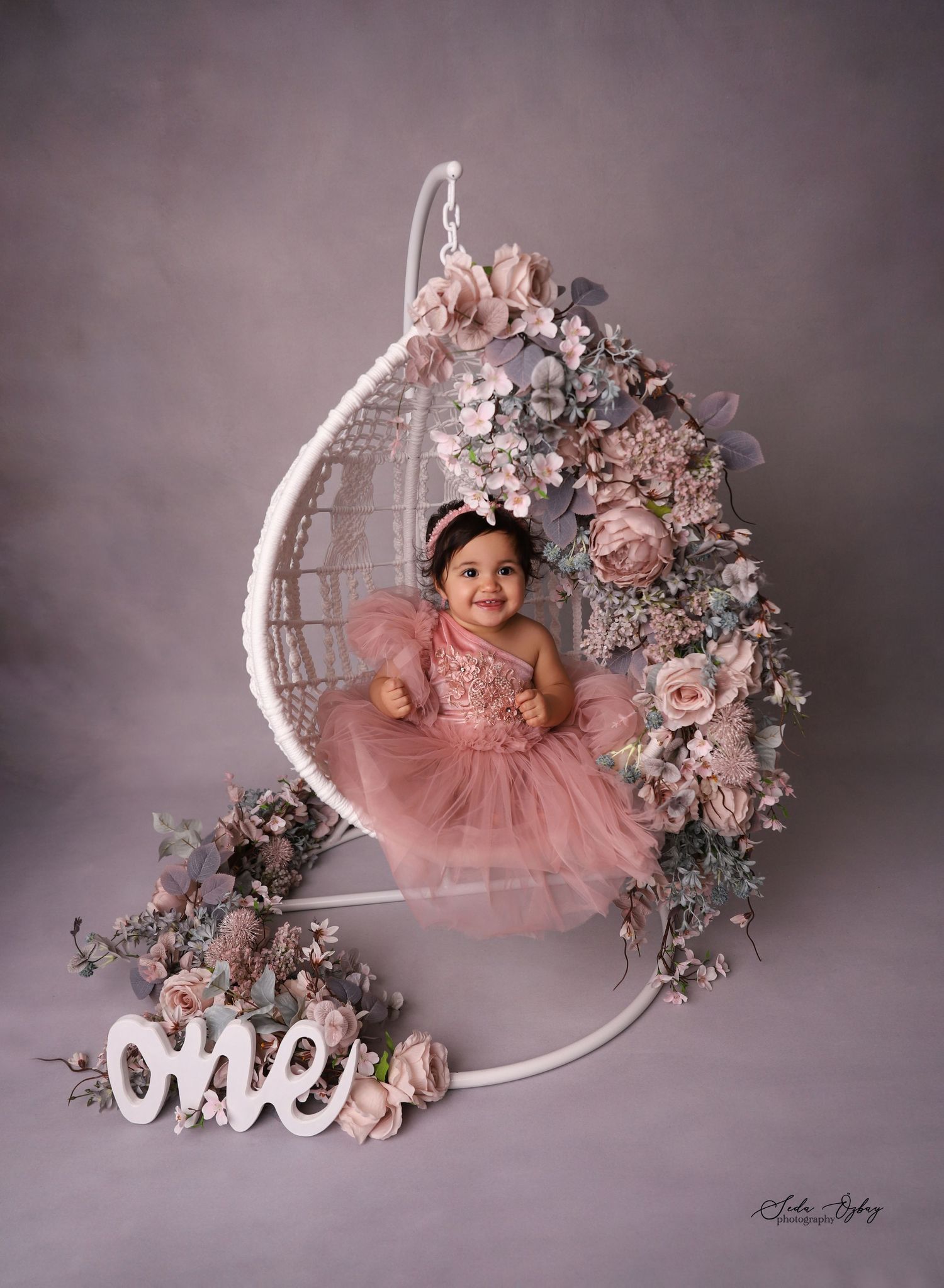 Pink floral moon prop setup with decorative 'one' text for baby photography.