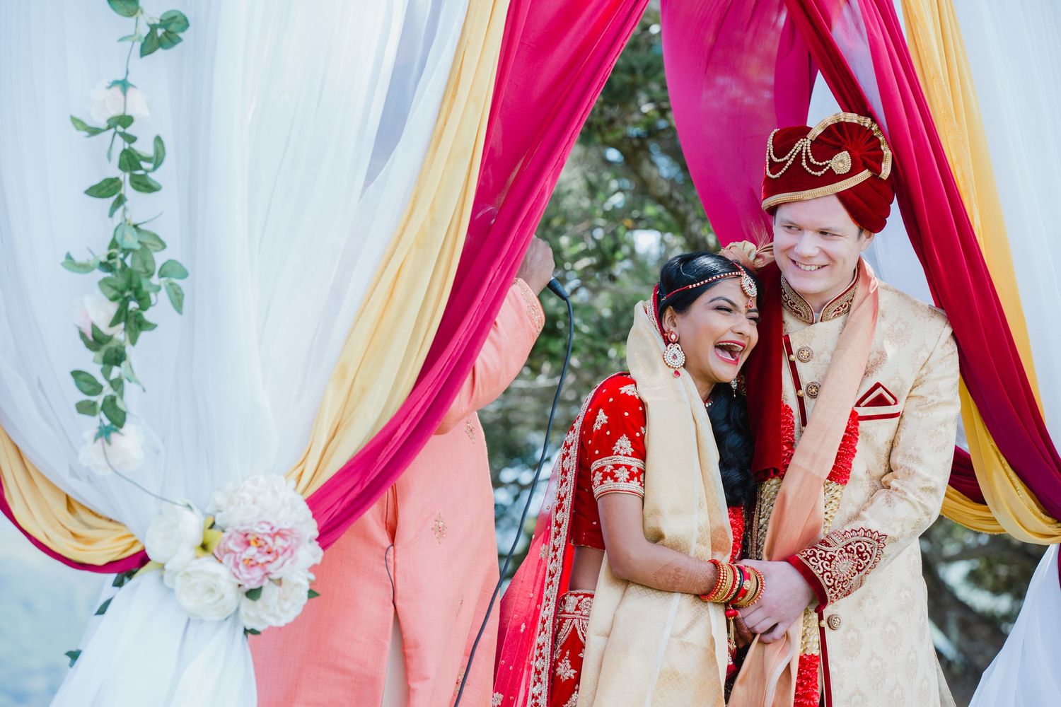 Auckland wedding photographer capturing a multicultural couple laughing during their traditional Indian wedding ceremony.