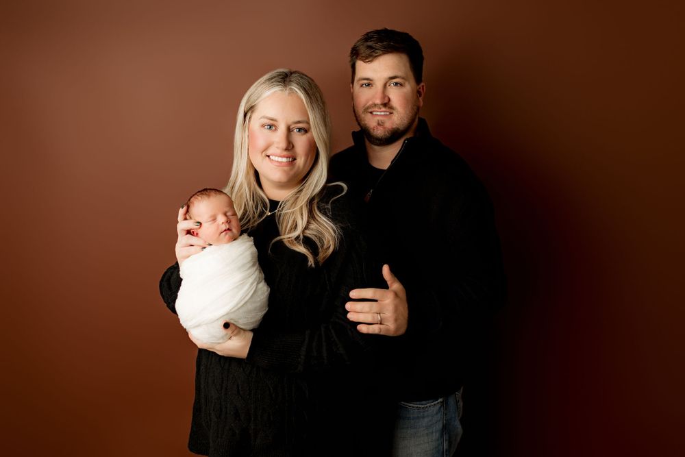 Baby Easton with his proud mom and dad, all smiling warmly during their newborn photography session at Bailey’s Photography in Scioto County