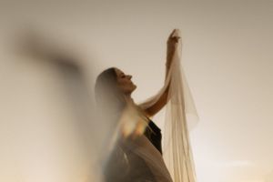 Dramatische Silhouette einer Tänzerin in fließendem Stoff in Bewegung.