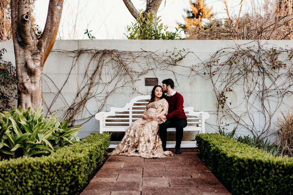 couple-sat-on-bench-in-english-garden-hamilton-gardens-waikato-maternity-photo