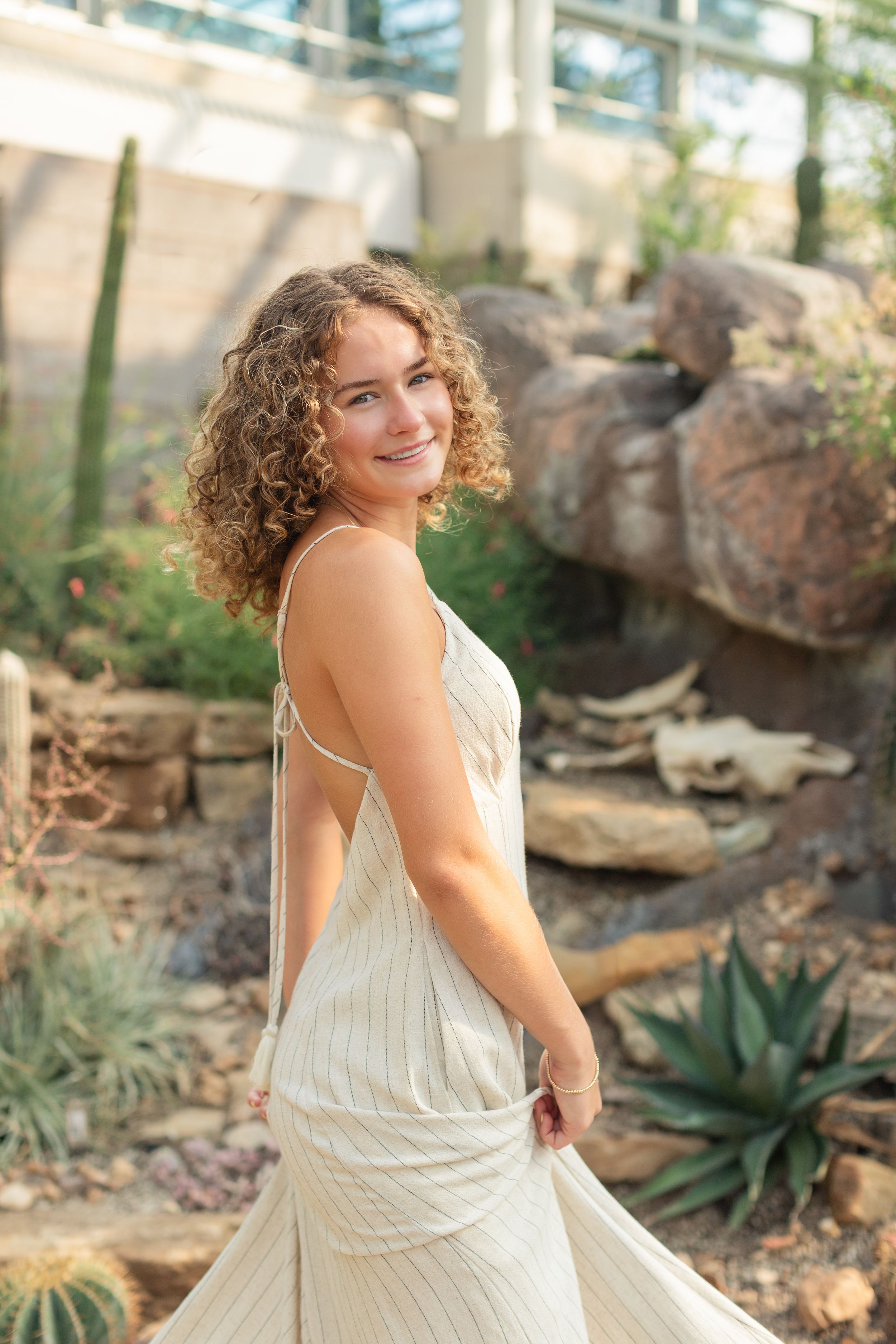 High school senior smiling during her St. Louis senior portraits at the Botanical Gardens. Authentic senior photography by Faith’s Flicks.