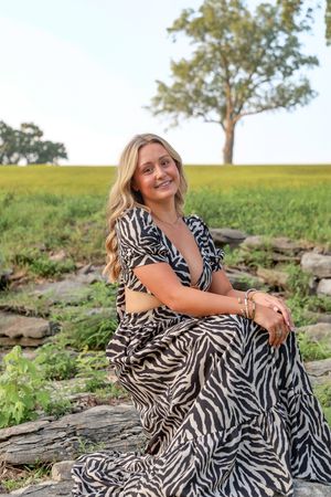 High school senior smiling during her St. Louis senior photos at Sunset Country Club. Authentic senior photography by Faith’s Flicks.