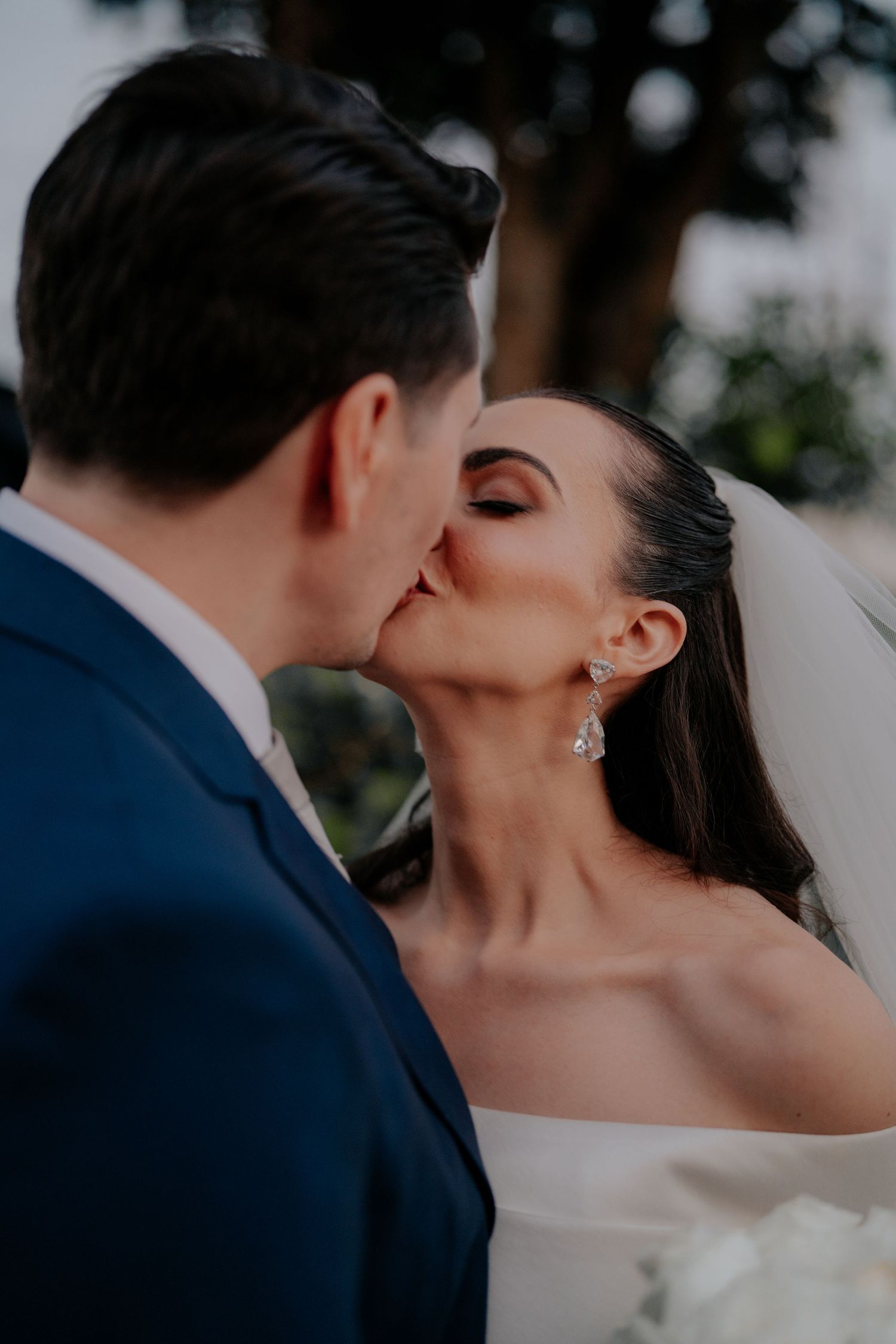 Intimate wedding photo showing couple sharing a romantic kiss.