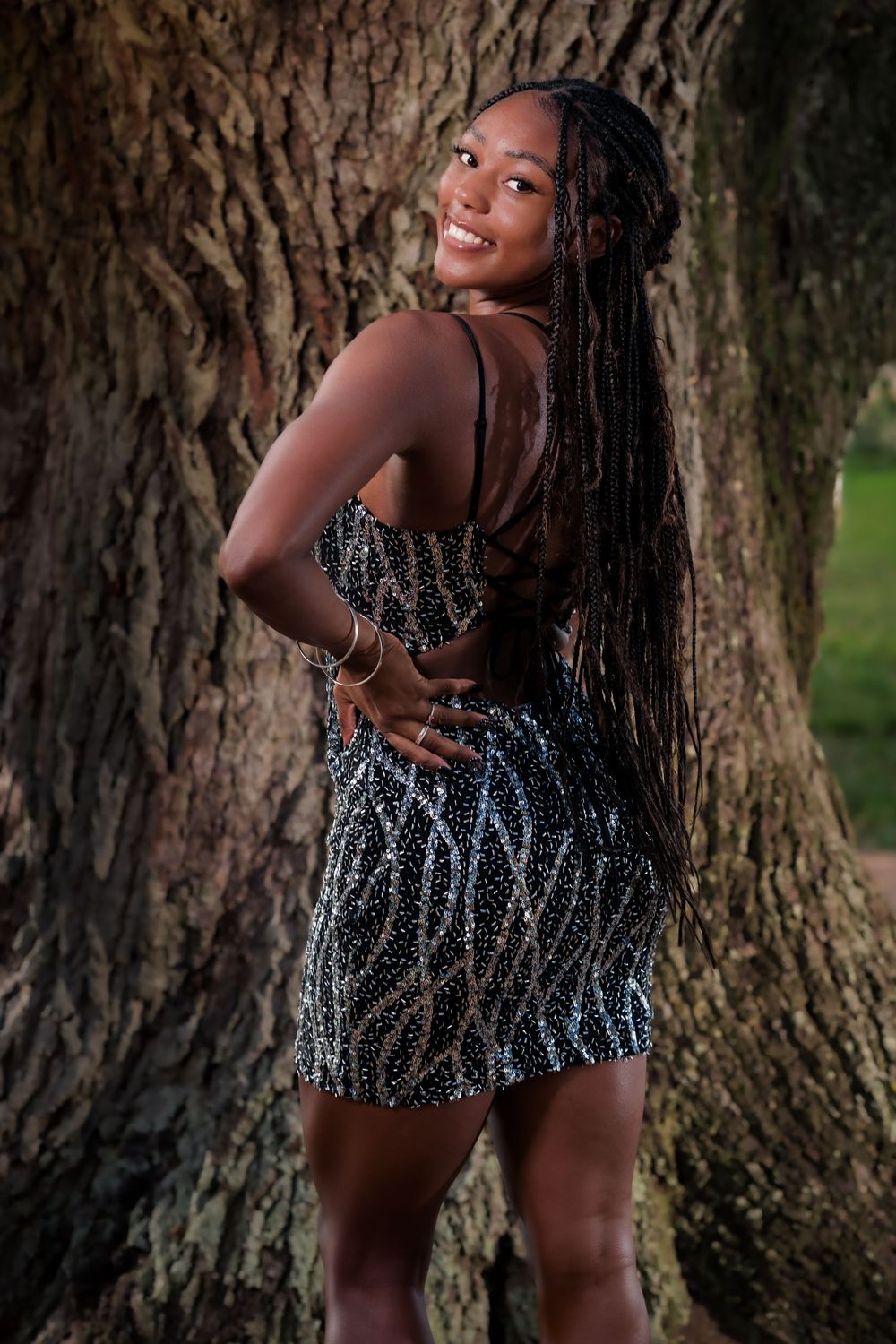 Artistic portrait series against a tree trunk backdrop featuring a sparkly silver sequined dress.
