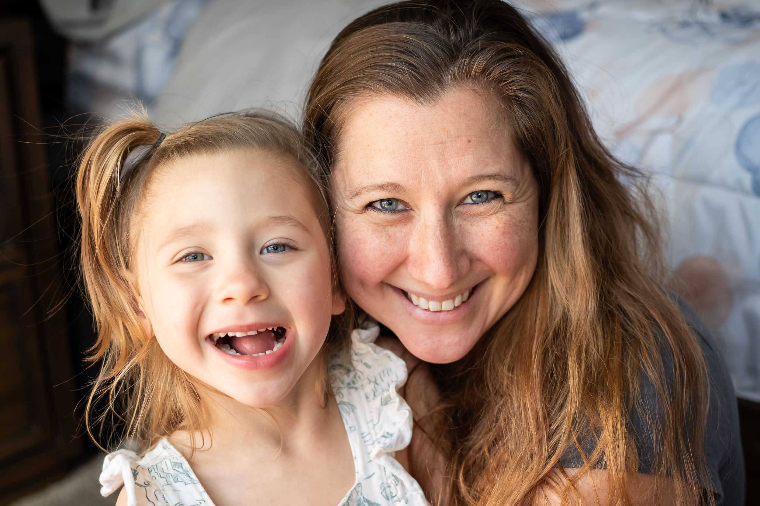 mom and daughter posed together smiling for a family session