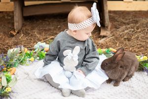 child sitting with a bunny on the ground for a themed easter photo session