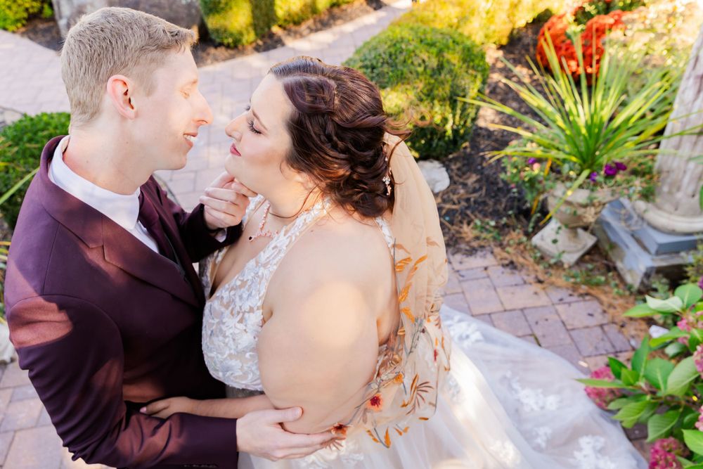 Intimate wedding portrait in a garden with colorful autumn landscaping.