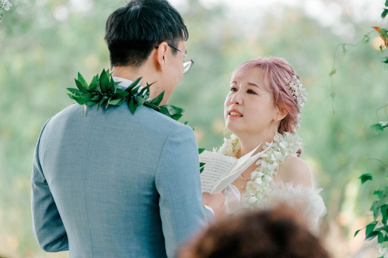 A romantic outdoor wedding photoshoot with a soft natural backdrop of greenery.