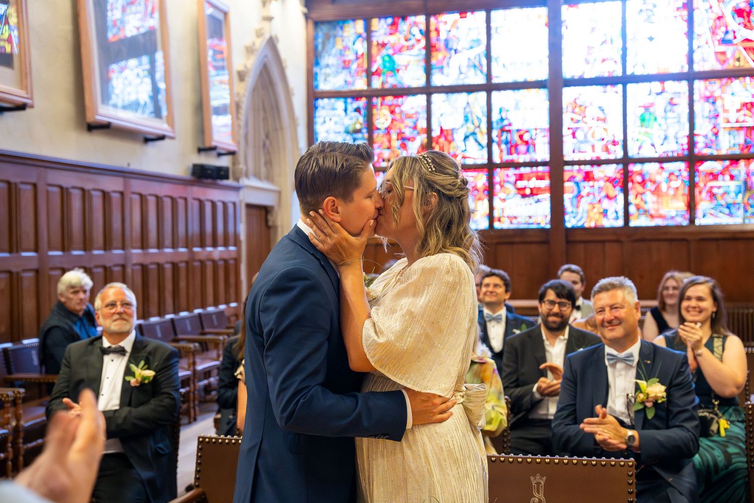 A romantic kiss celebration in a church with stained glass windows and wooden pews.