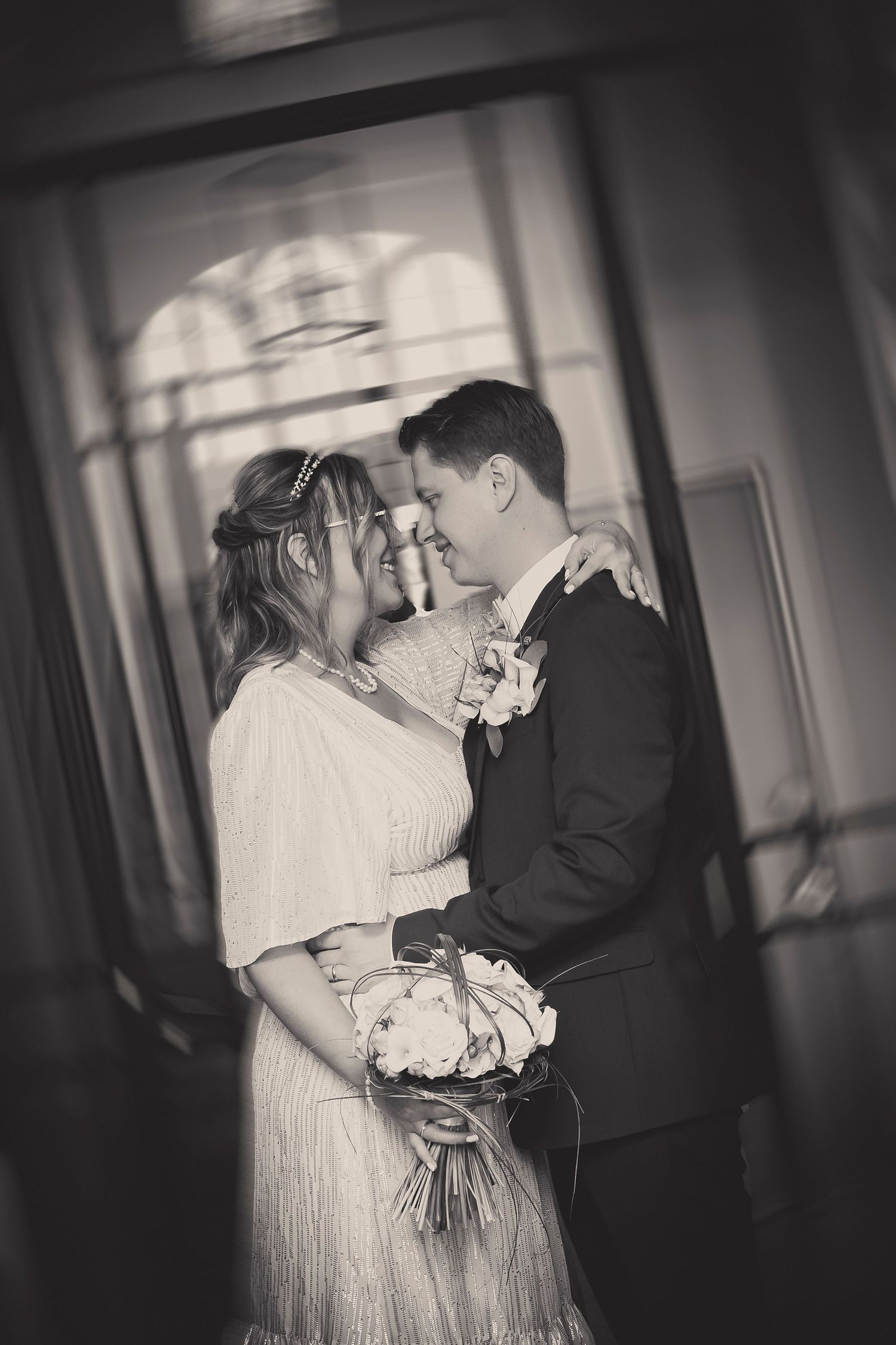 An intimate black and white portrait of a wedding couple sharing a romantic moment.