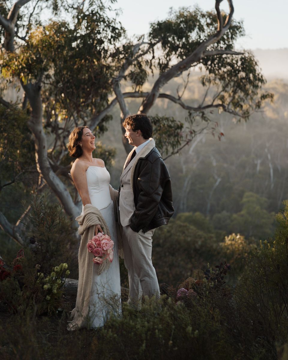Couple in wedding attire standing on a misty hilltop surrounded by eucalyptus trees at golden hour elopement photoshoot western sydney