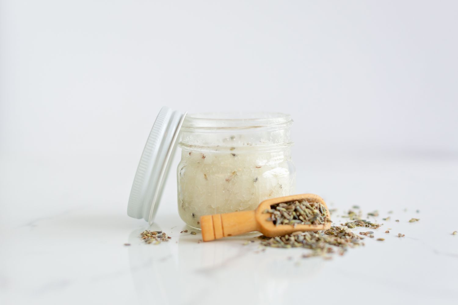 Creamy yogurt parfait ingredients with granola and nuts on white background.