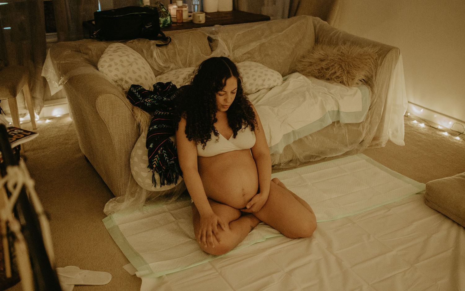A series of romantic sepia-toned boudoir photographs showing a person posing on white bedding.birth photographer london