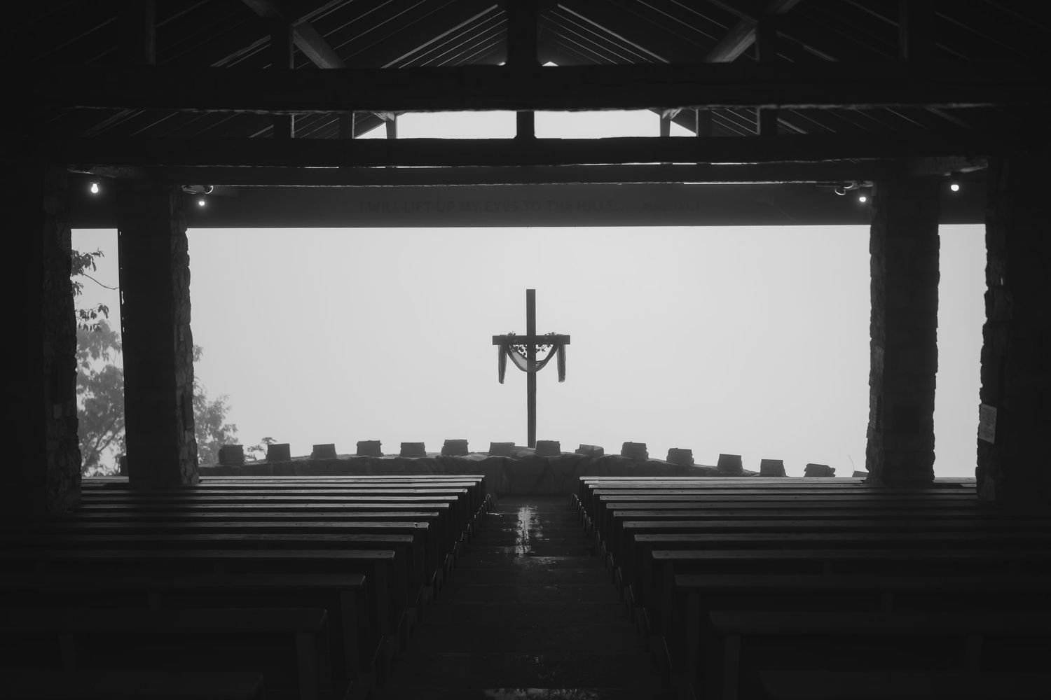 Black and white architectural photograph showing geometric patterns of light and shadow through window slats.