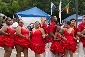 Dance group in matching red ruffled costumes performing a synchronized routine at a festival.