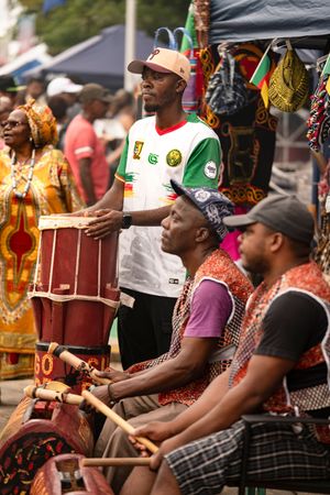 Festival attendees enjoy live music while sitting in chairs at an outdoor cultural event.