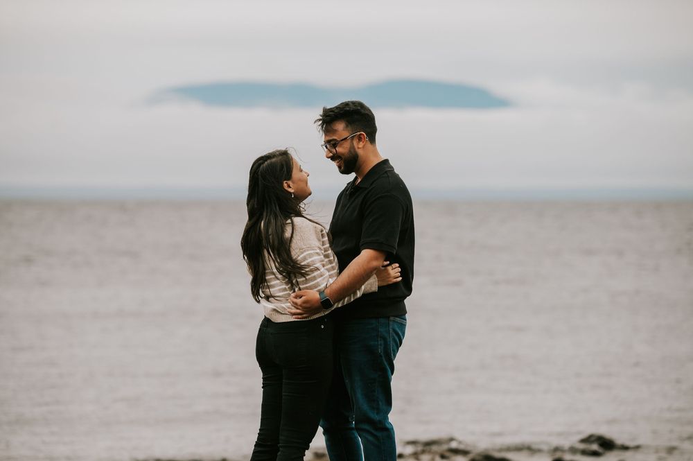 Professional Photographer Engagement Photoshoot at Neck Point Park, Nanaimo, Vancouver Island of couple in front of mountains across ocean