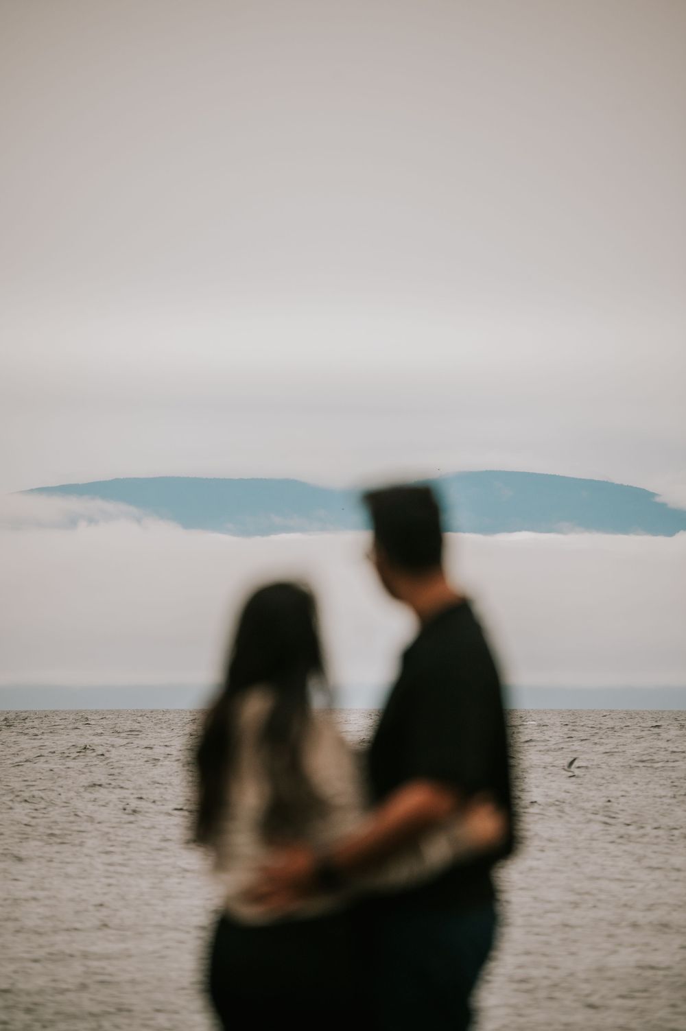 Professional Photographer Engagement Photoshoot at Neck Point Park, Nanaimo, Vancouver Island of couple looking at mountains across ocean