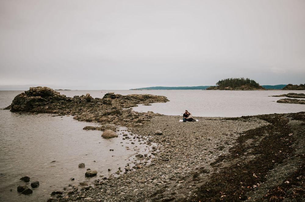 Neck Point Park, Nanaimo, Vancouver Island Engagement Photographer Photoshoot of couple sitting on picnic blanket snuggling