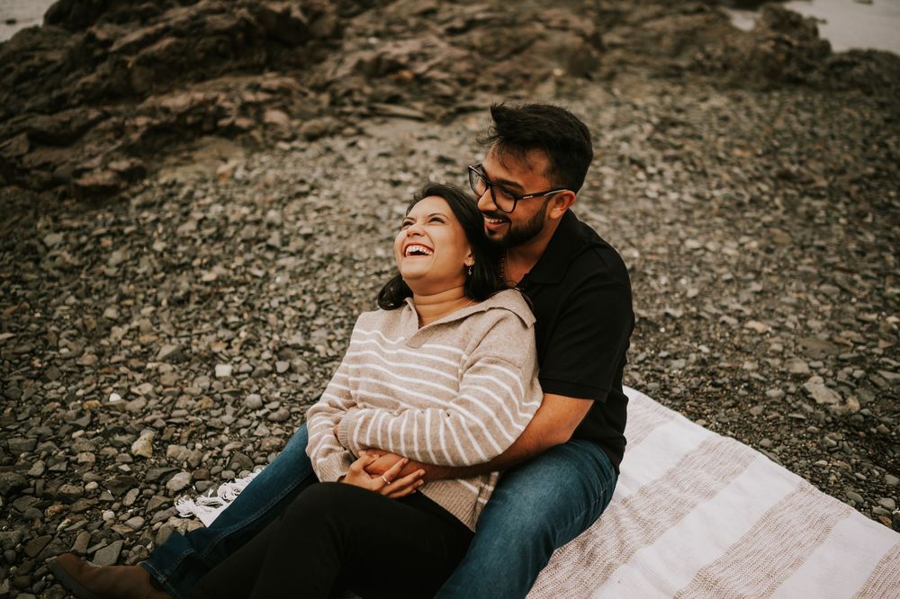 Professional Photographer Engagement Photoshoot at Neck Point Park, Nanaimo, Vancouver Island of couple laughing and sitting pose