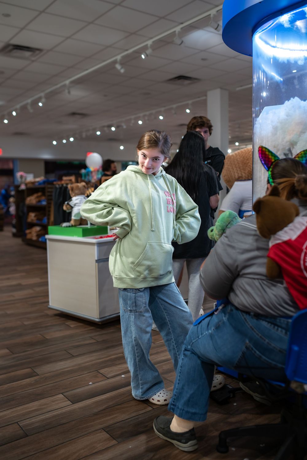 A sequence of images showing someone dabbing in a retail store with wood flooring and bright lighting.