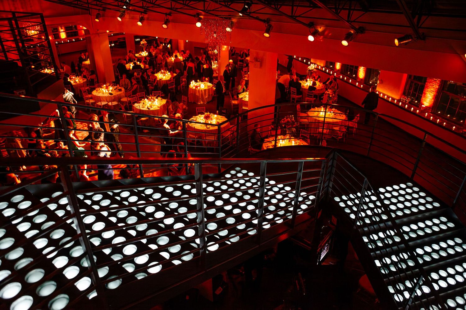 Wedding venue illuminated in dramatic red lighting with geometric patterns casting shadows.