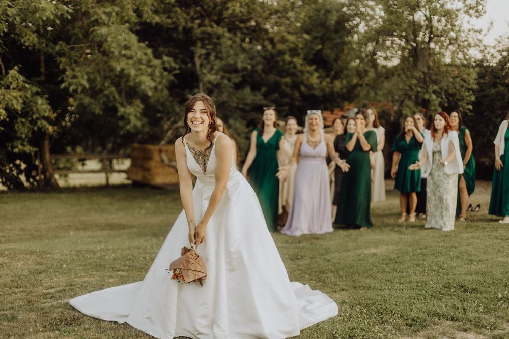 Elegant outdoor wedding party photos featuring white and lavender dresses in a lush garden setting.