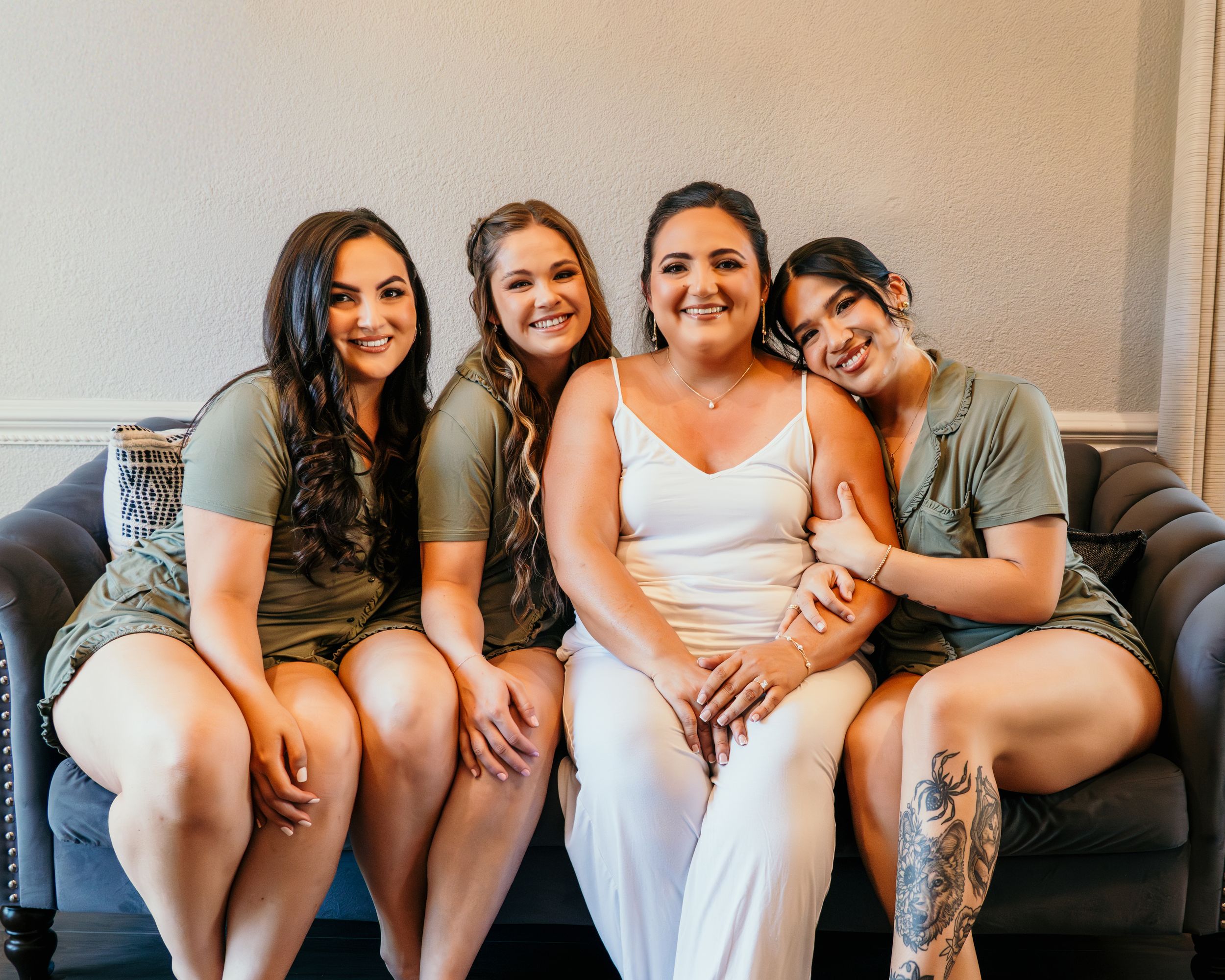 A group of friends sitting close together on a couch in a casual indoor setting.