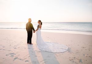 Romantic sunset beach wedding photos with footprints in the sand.
