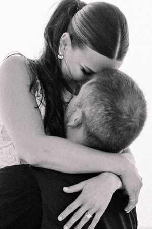 A black and white intimate portrait of a couple embracing.