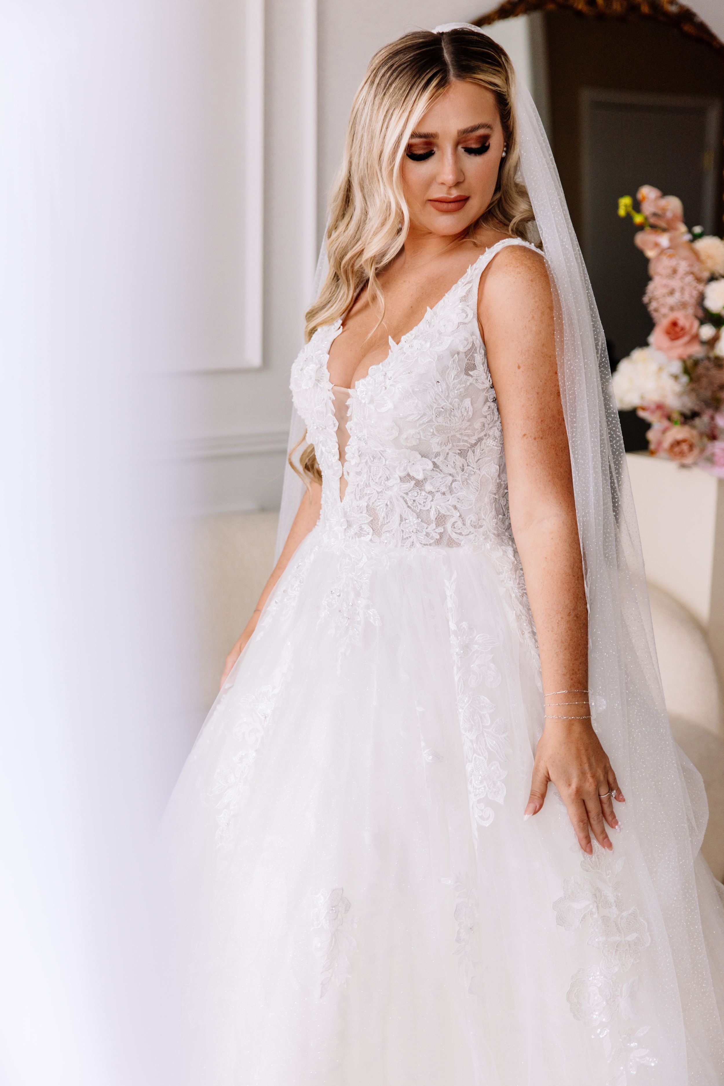 White lace wedding dress details with full tulle skirt displayed in elegant setting.
