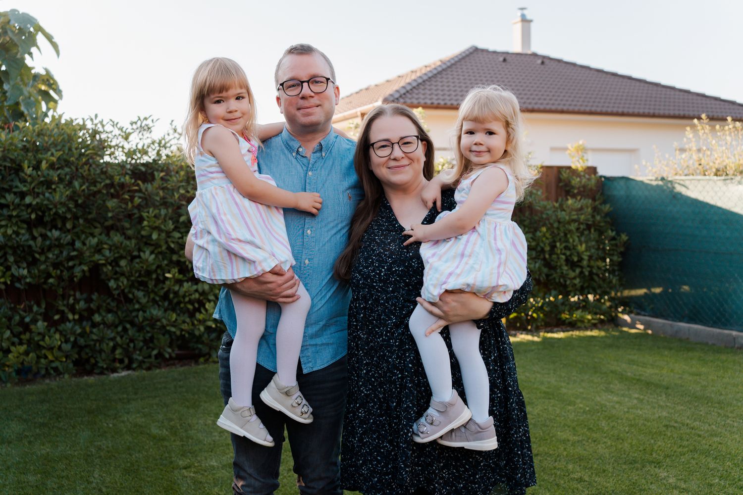A family poses together in their Rouse Hill home's garden during a family photoshoot in natural afternoon light