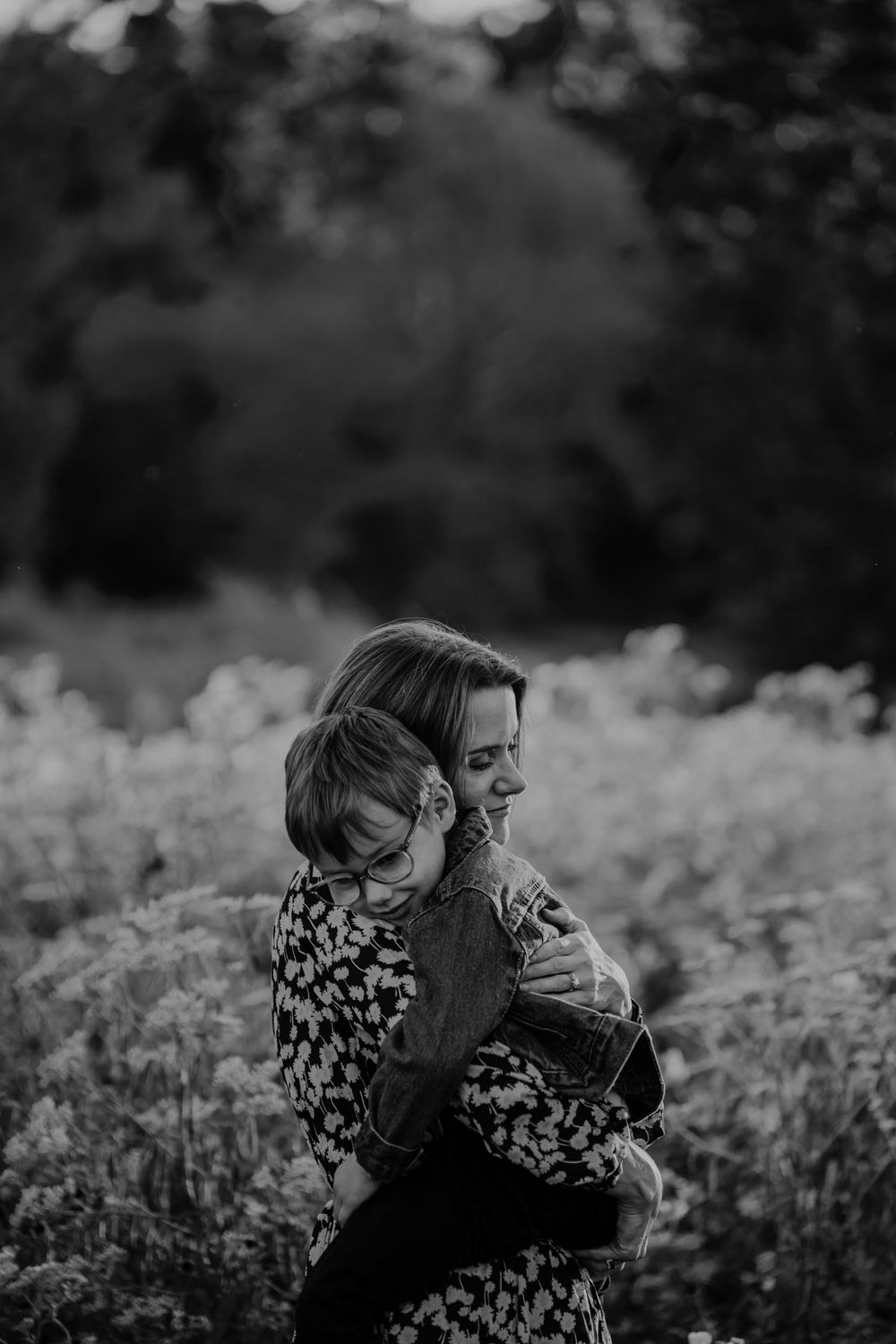 A black and white portrait captures an intimate embrace in a field of flowers at dusk at Cascade Valley Metro Park, Akron, Ohio, Family Pics