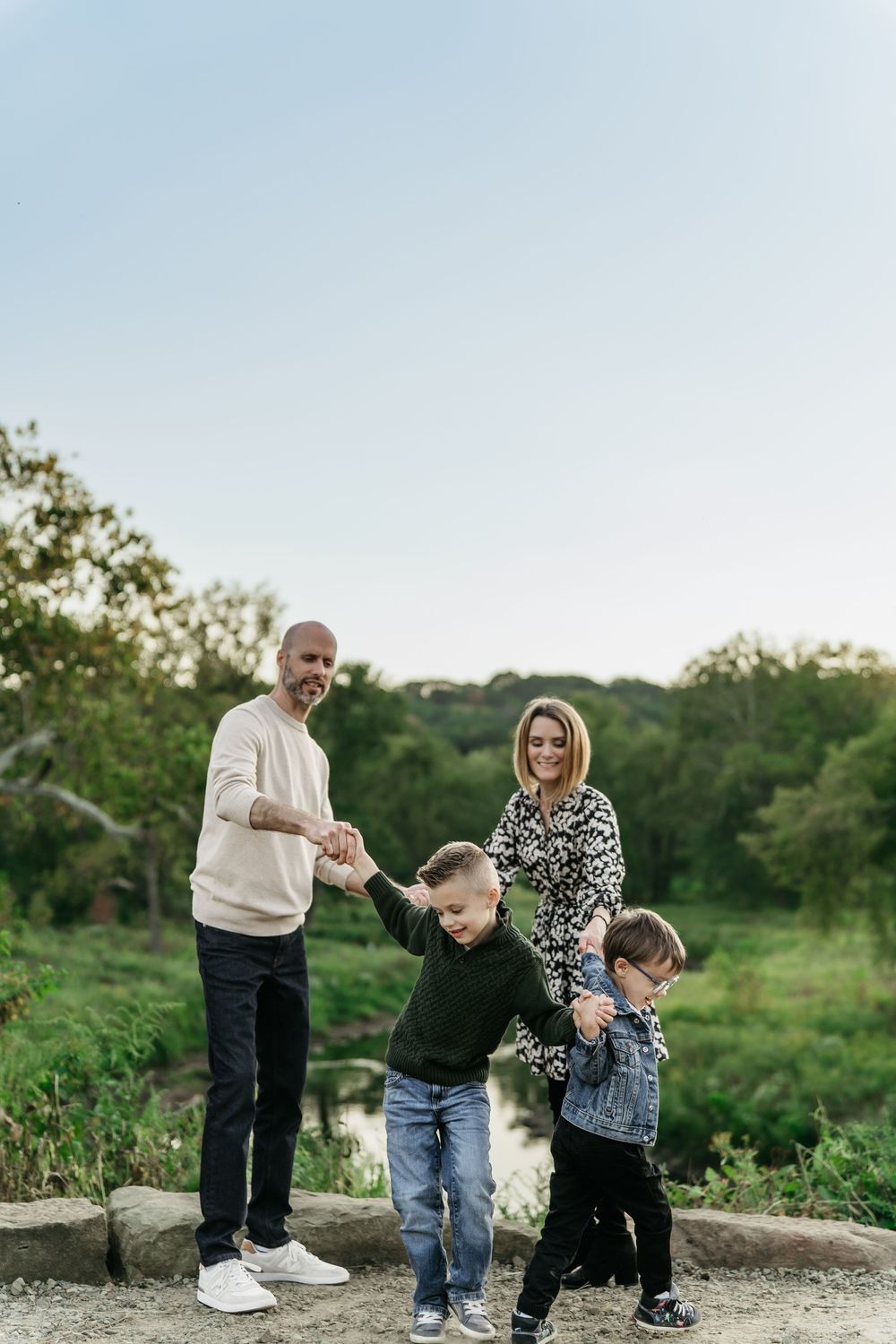 Family spending time together outdoors near a pond surrounded by green vegetation at Cascade Valley Metro Park in Akron, Ohio Family Session