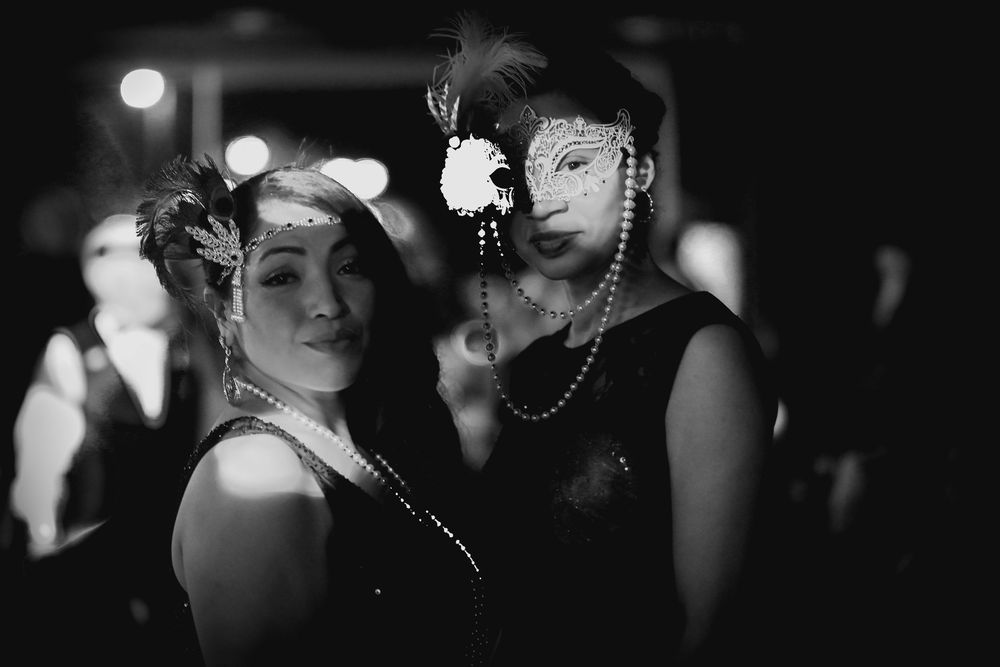 Black and white photo of people dancing at a nighttime social event.