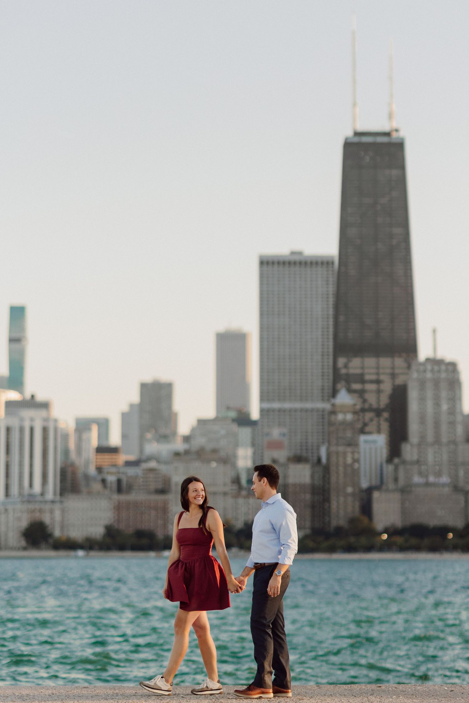 Couple shares intimate moment with Chicago's iconic waterfront skyline in background.