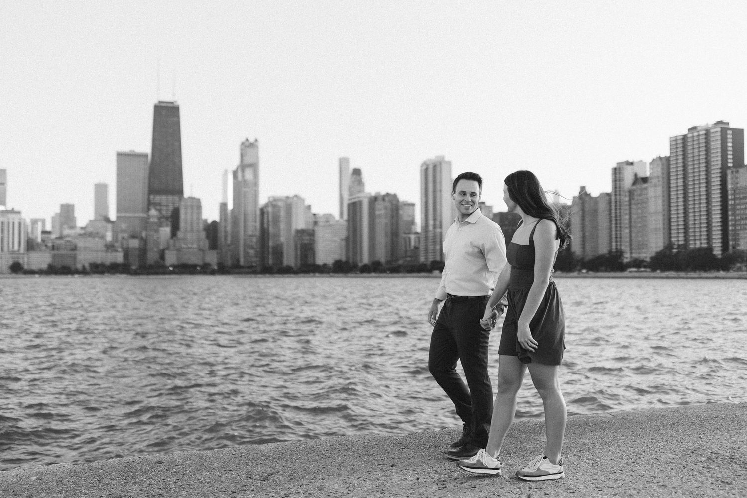 Silhouetted couple against dramatic Chicago cityscape and Lake Michigan waters.