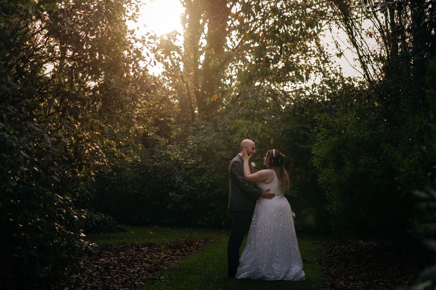 Silhouetted wedding photography session in forest during golden hour sunset.