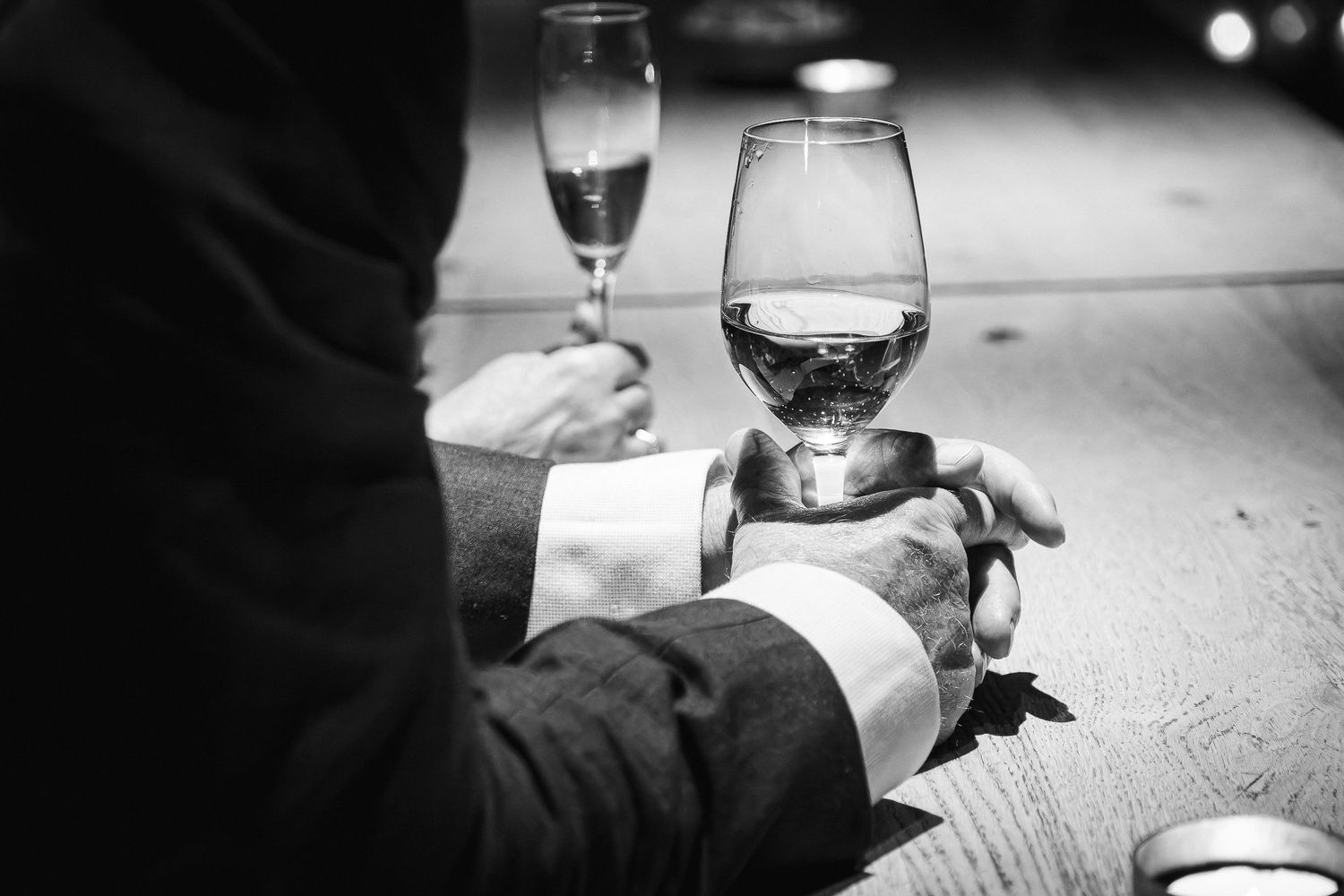 Wine glasses clink together in celebration at an elegant event.