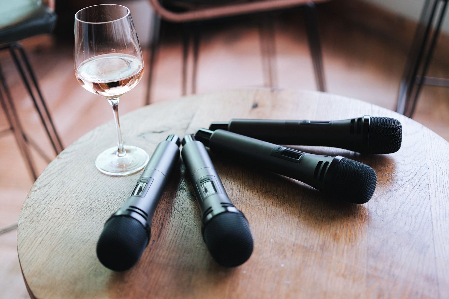 Wine glasses and microphones arranged on a wooden surface.