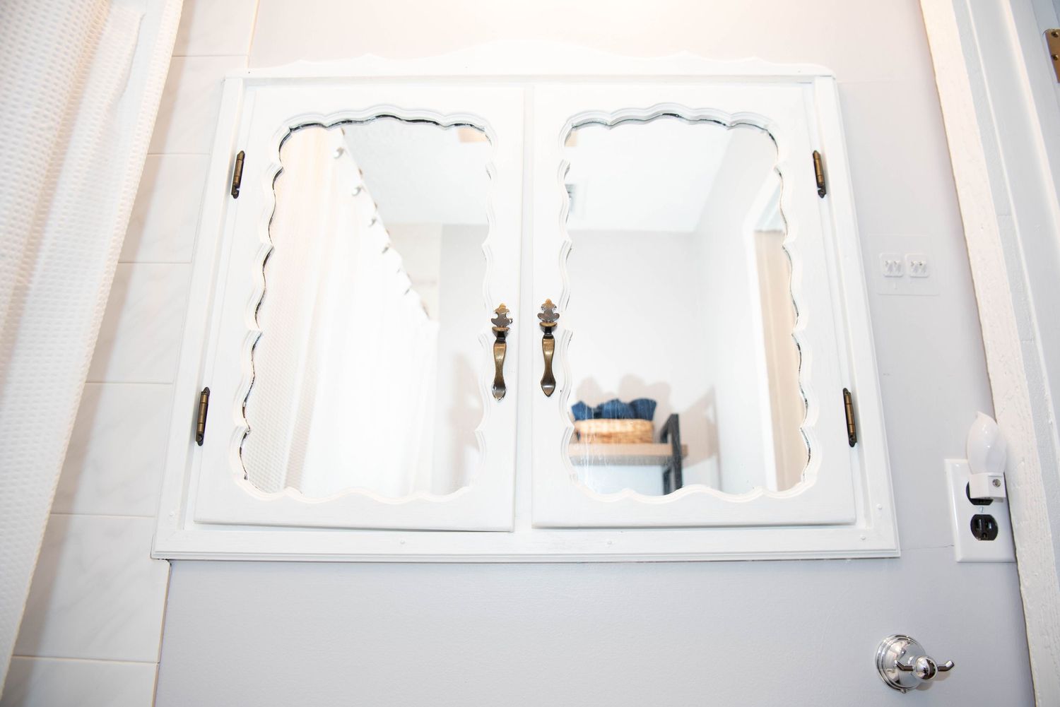 Row of white windows with wall sconces in a bright, minimalist interior setting.