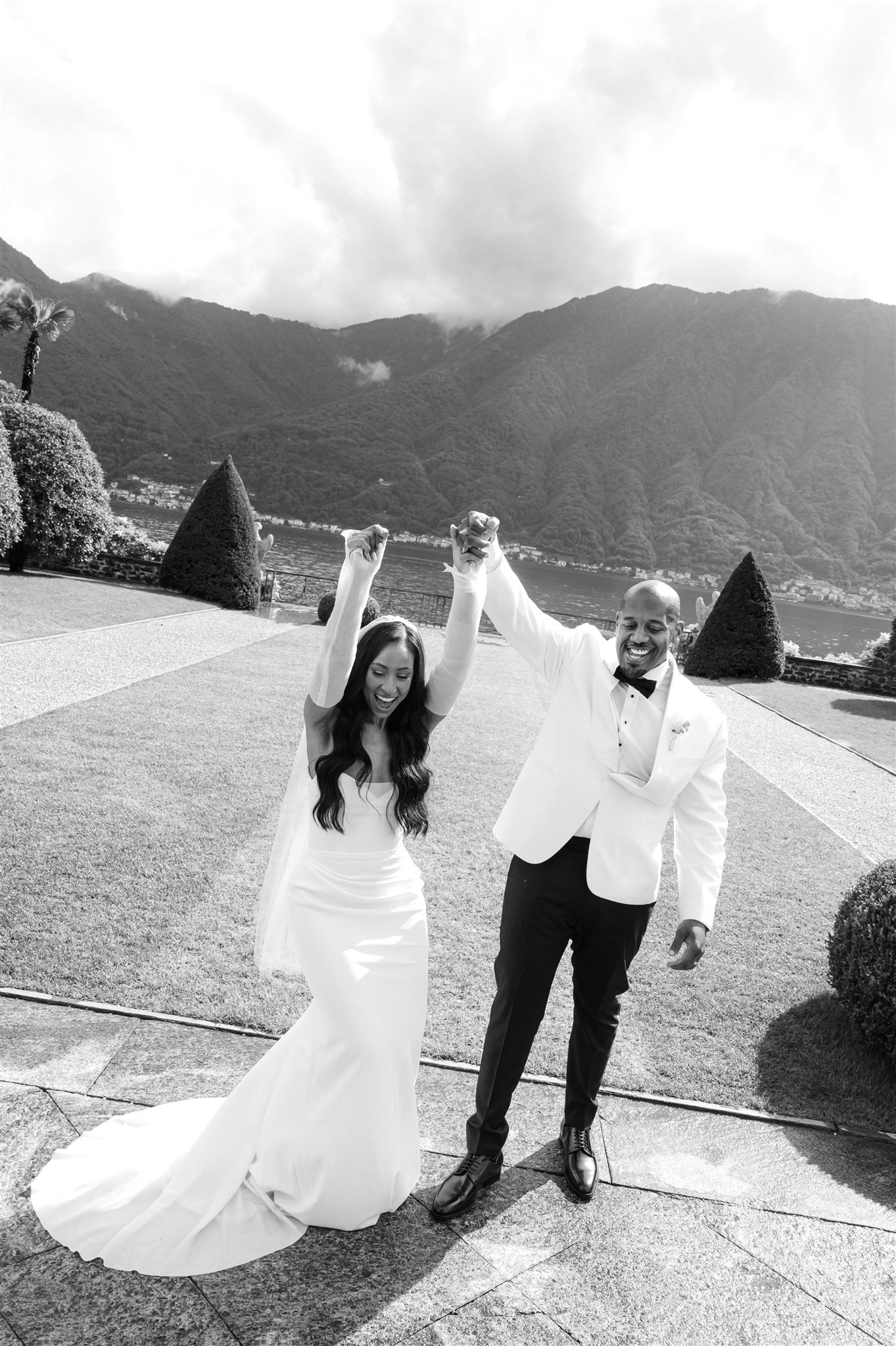 Black and white wedding photos showing playful moments between a couple in a garden setting.