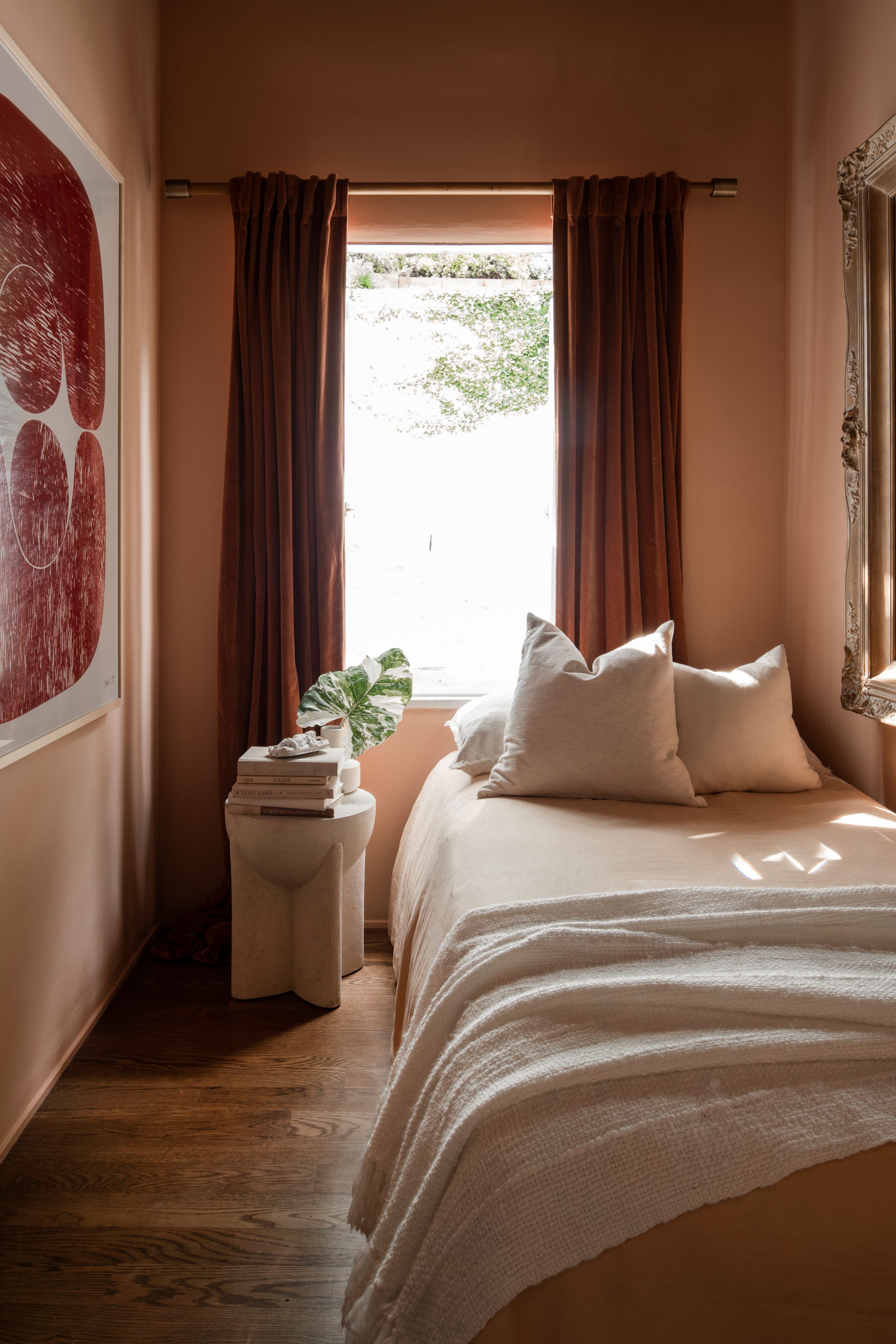 Serene bedroom interior with white bedding, brown curtains, and sunlit windows showcasing modern minimalist decor.