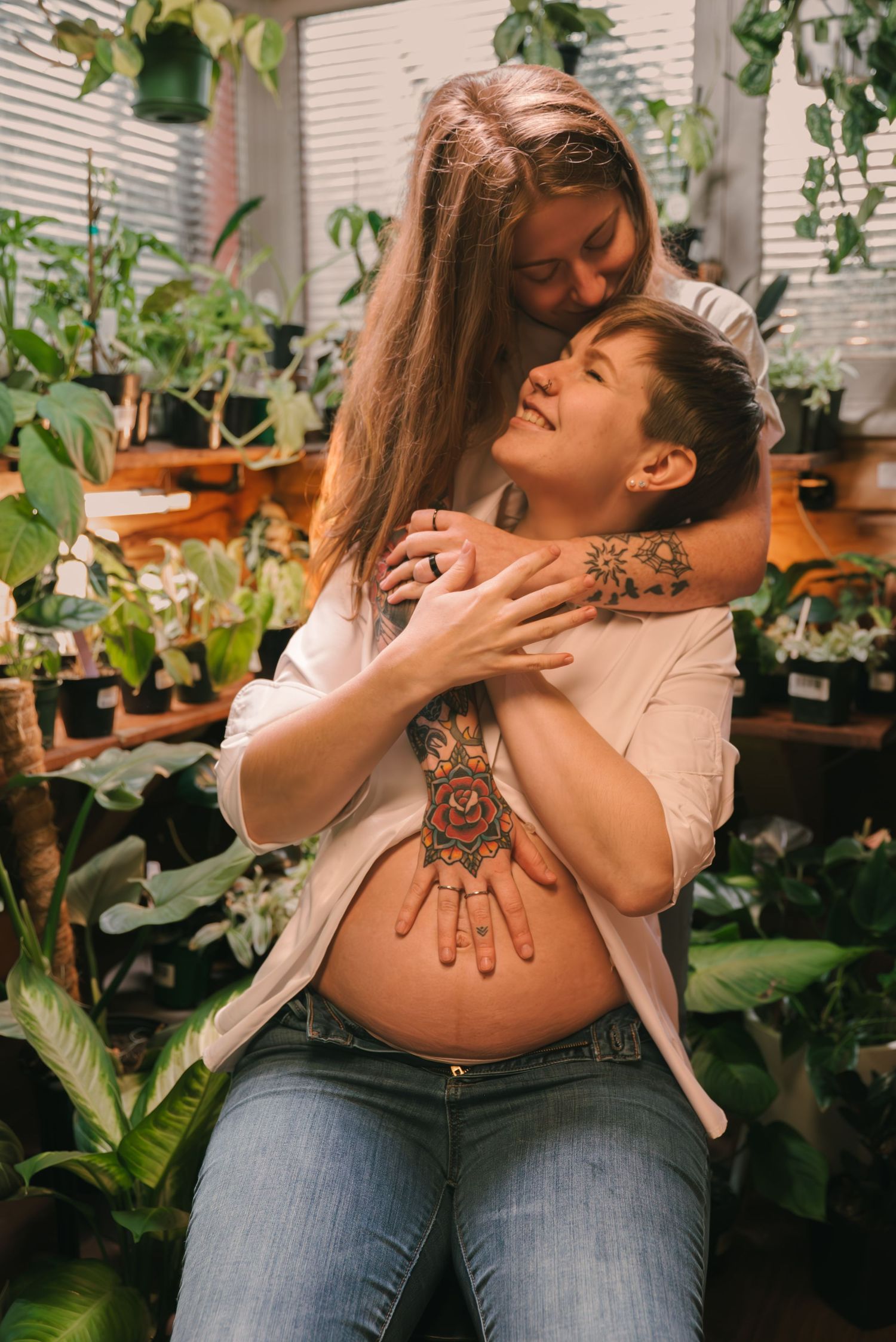 Indoor plant enthusiast shows off intricate henna design on back while surrounded by potted houseplants and greenery.