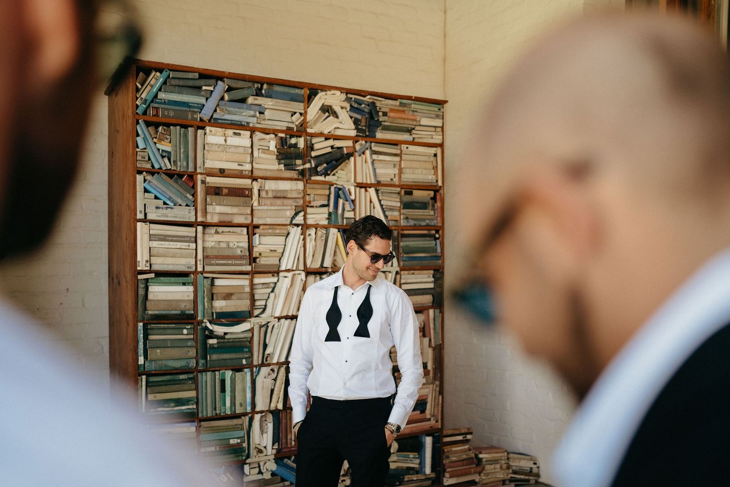 A wedding couple shares intimate moments in a rustic setting with vintage wooden shutters in the background.
