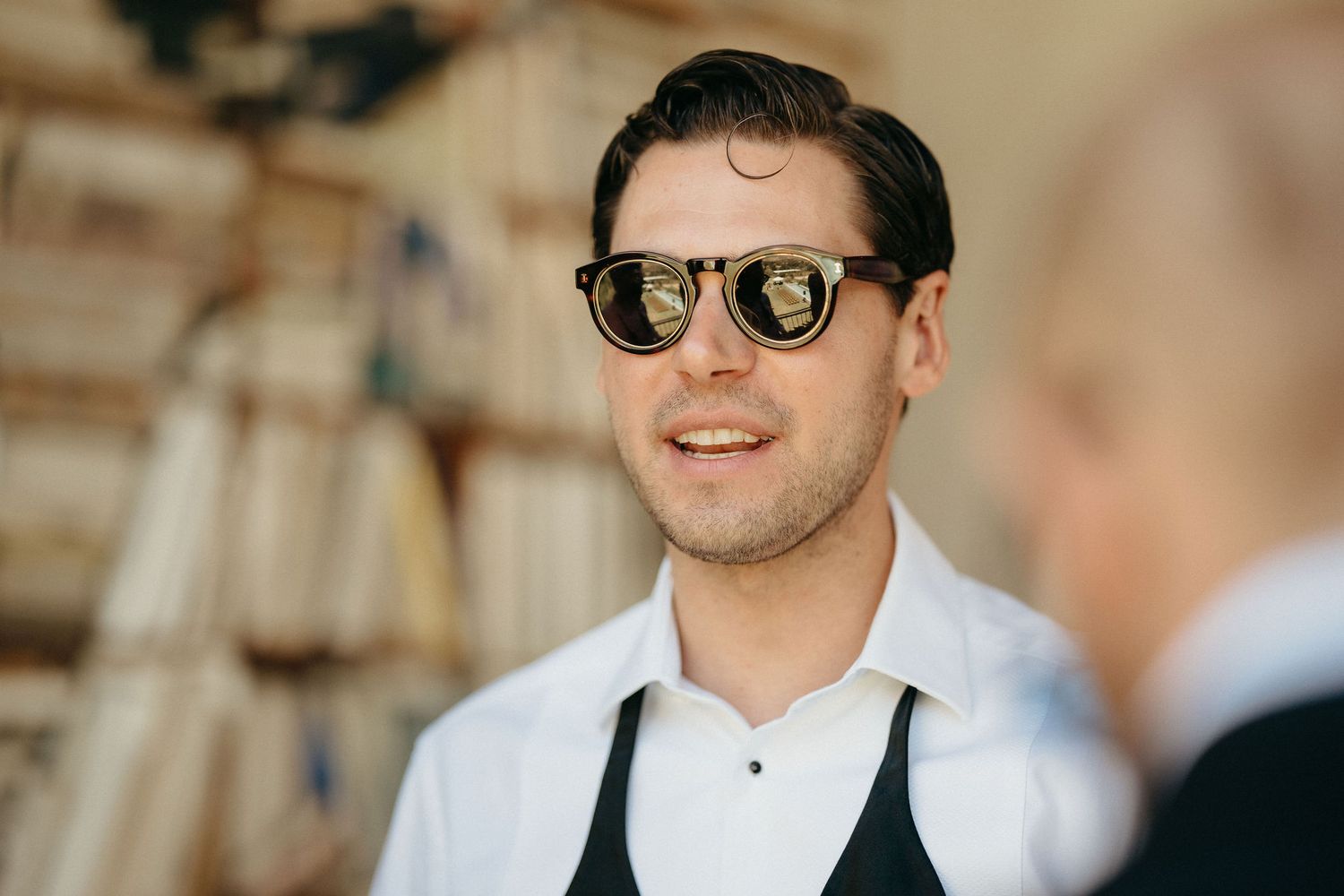 A series of candid moments showing a person wearing sunglasses and formal attire at an outdoor event.